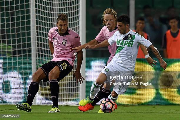 Stefano Sensi of Sassuolo holds off the challenge from Thiago Cionek and Oscar Hiljemark of Palermo during the Serie A match between US Citta di...