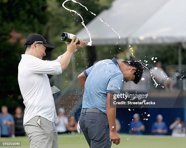 Rampert Sim pours champagne on Si Woo Kim after winning the Wyndham Championship during the final round at Sedgefield Country Club on August 21, 2016...