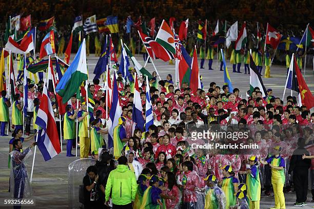 Athletes of Team Japan wearing rain coats parade during the 'Heroes of the Games' segment during the Closing Ceremony on Day 16 of the Rio 2016...