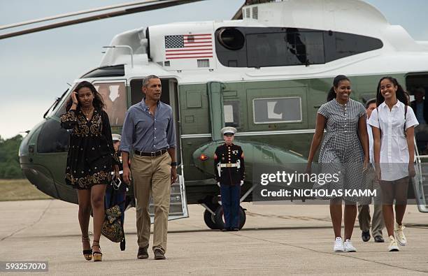 President Barack Obama, First Lady Michelle Obama and daughters Malia and Sasha walk to board Air Force One at Cape Cod Air Force Station in...