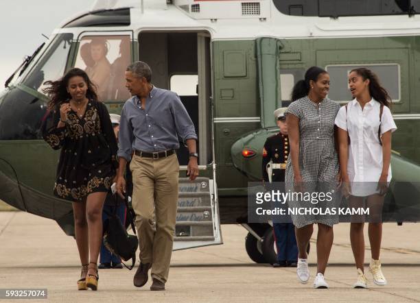 President Barack Obama, First Lady Michelle Obama and daughters Malia and Sasha walk to board Air Force One at Cape Cod Air Force Station in...