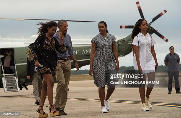 President Barack Obama, First Lady Michelle Obama and daughters Malia and Sasha walk to board Air Force One at Cape Cod Air Force Station in...