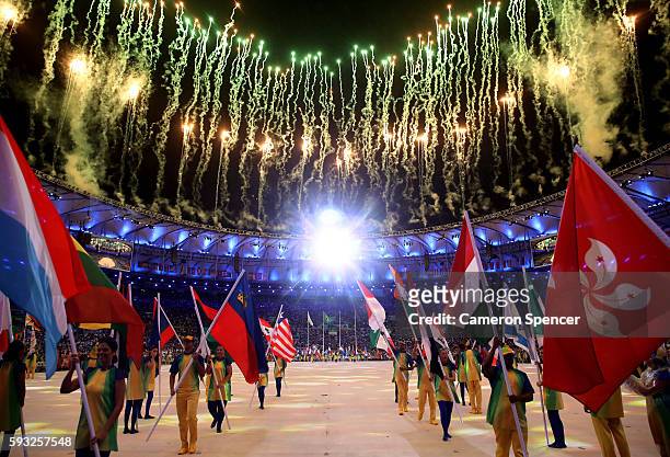 Athletes walk during the 'Heroes of the Games' segment as fireworks explode during the Closing Ceremony on Day 16 of the Rio 2016 Olympic Games at...