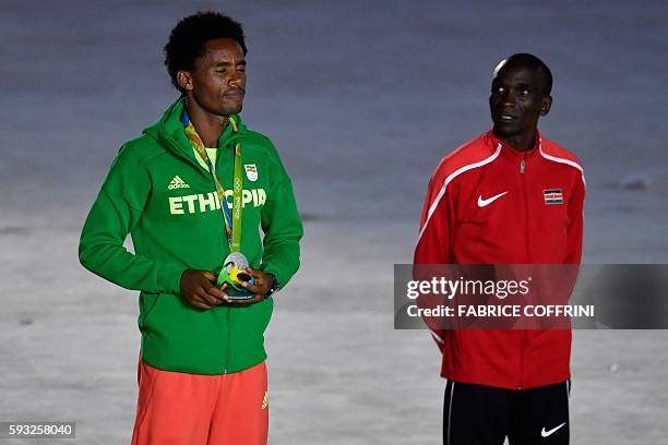 Silver medallist Ethiopia's Feyisa Lilesa poses on the podium of the men's marathon during the closing ceremony of the Rio 2016 Olympic Games at the...