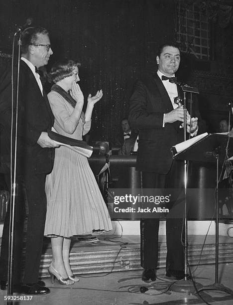 Actor Ernest Borgnine and Jean Simmons on stage receiving his Best Actor award, with actors Dick Powell and June Allyson, at the Foreign Press...