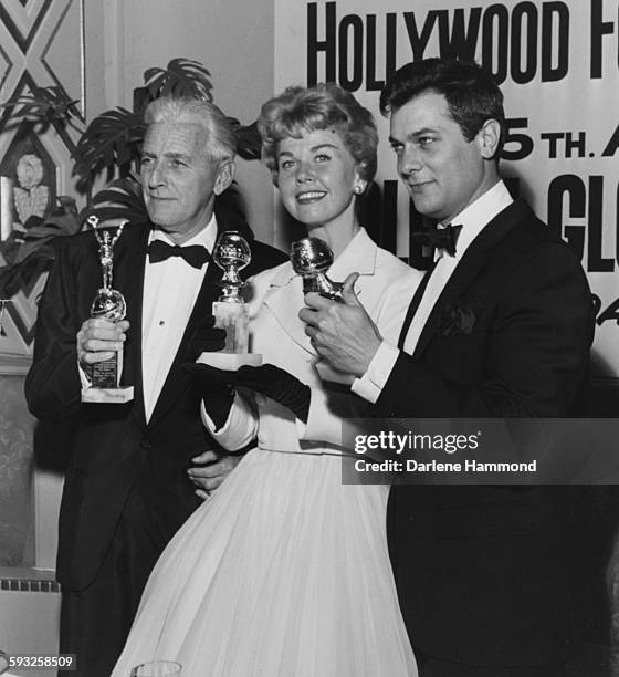 Actors Buddy Adler, Doris Day and Tony Curtis with their statuettes at the Foreign Press Awards, or the Golden Globes, in Hollywood, 1958.