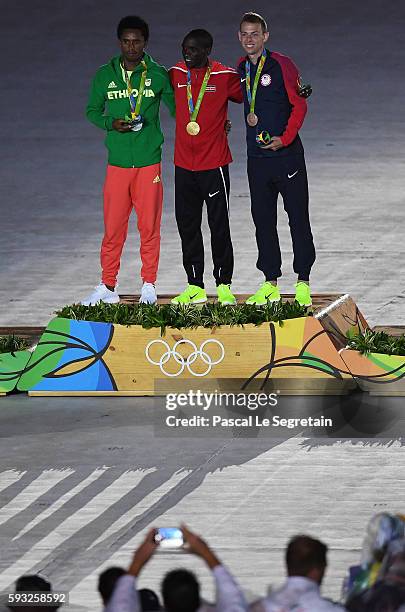 Silver medalist Feyisa Lilesa of Ethiopia, gold medalist Eliud Kipchoge of Kenya and bronze medalist Galen Rupp of the United States celebrate on the...