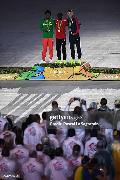 Silver medalist Feyisa Lilesa of Ethiopia, gold medalist Eliud Kipchoge of Kenya and bronze medalist Galen Rupp of the United States celebrate on the...