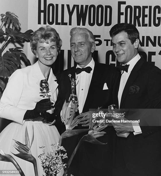 Actors Doris Day, Buddy Adler and Tony Curtis with their statuettes at the Foreign Press Awards, or the Golden Globes, in Hollywood, 1958.