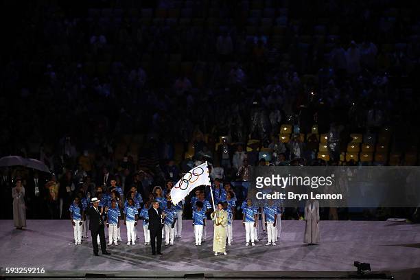 Governor of Tokyo Yuriko Koike waves the IOC flag while IOC President Thomas Bach and the Mayor of Rio de Janeiro Eduardo Paes watch on stage at the...