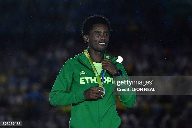 Silver medallist Ethiopia's Feyisa Lilesa poses on the podium for the Men's marathon athletics event during the closing ceremony of the Rio 2016...