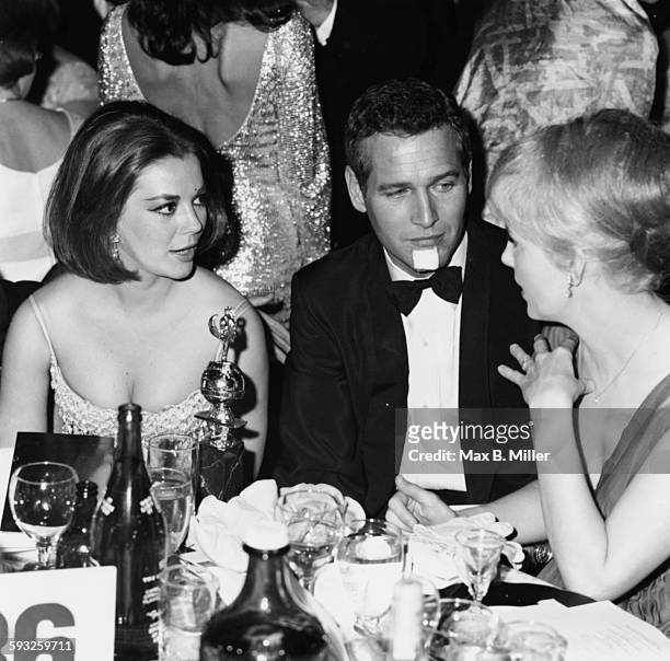 Actors Natalie Wood, Paul Newman and Joanne Woodward sitting at their table at the Golden Globe Awards, 1965.