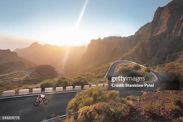 cyclist on beautiful road in mountains at sunset - cycliste photos et images de collection