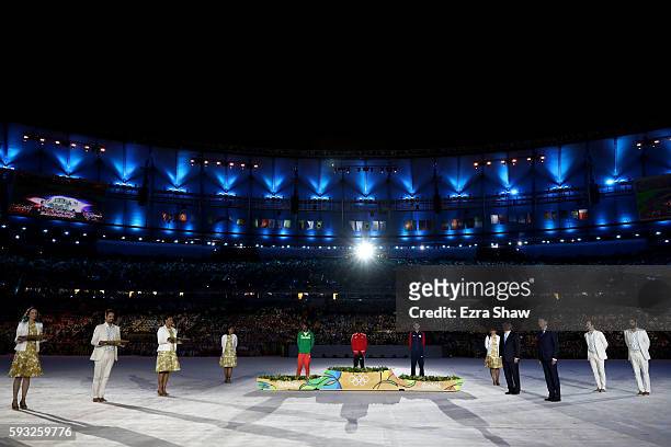 Silver medalist Feyisa Lilesa of Ethiopia, gold medalist Eliud Kipchoge of Kenya and bronze medalist Galen Rupp of the United States stand during the...
