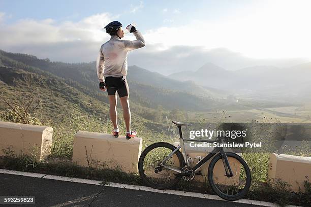 cyclist drinking and looking at view - arrière bus photos et images de collection