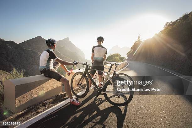 two cyclists watching at sunset in mountains - 單車衫 個照片及圖片檔