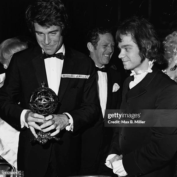 Actor Warren Beatty holding his award, with Michael J Pollard, at the Golden Globe Nomination party, 1968.