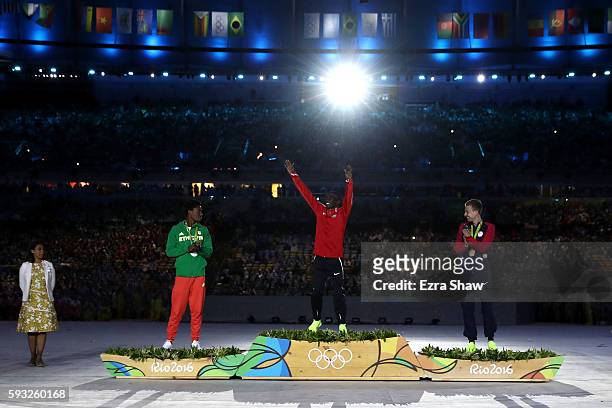 Silver medalist Feyisa Lilesa of Ethiopia, gold medalist Eliud Kipchoge of Kenya and bronze medalist Galen Rupp of the United States celebrate during...