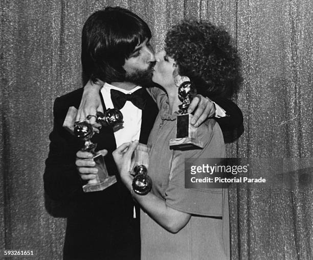 Actress Barbra Streisand and producer Jon Peters kissing as they hold their awards for the film 'A Star is Born', at the Golden Globe Awards, Los...