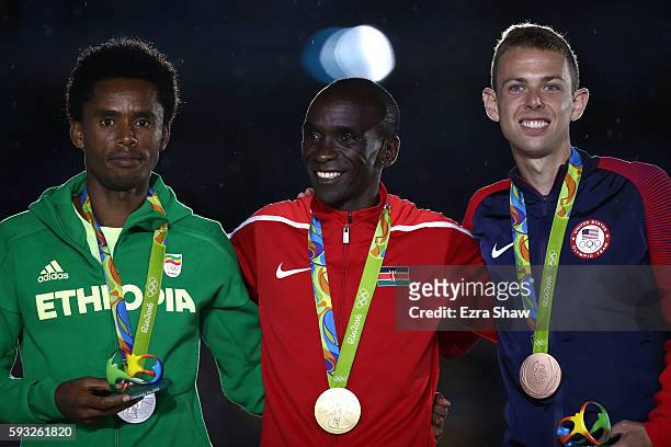 Silver medalist Feyisa Lilesa of Ethiopia, gold medalist Eliud Kipchoge of Kenya and bronze medalist Galen Rupp of the United States celebrate during...