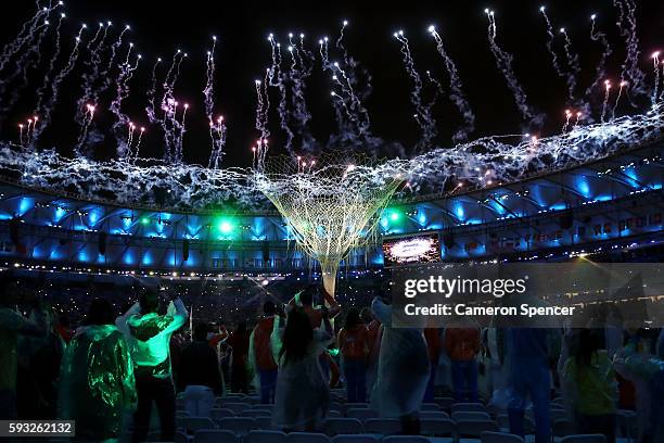 Spectators take photos as fireworks explode near the conclusion of the Closing Ceremony on Day 16 of the Rio 2016 Olympic Games at Maracana Stadium...