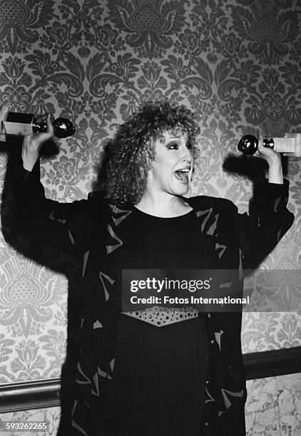 Actress Bette Midler holding her two awards in the air, both for the film 'The Rose', at the Golden Globe Awards, Los Angeles, January 1980.