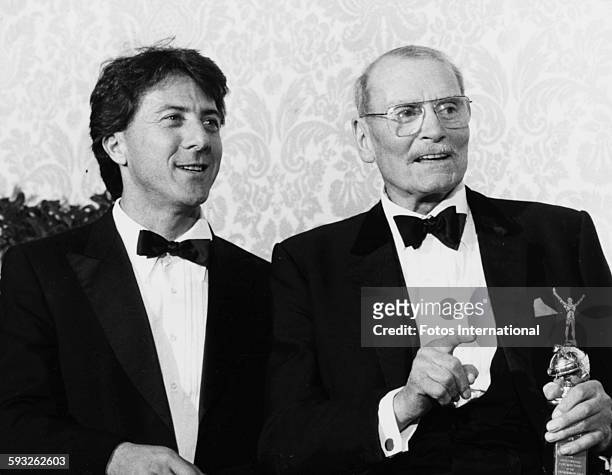 Actor Sir Laurence Olivier holding his Cecil B DeMille award, with presenter Dustin Hoffman , at the Golden Globe Awards, at the Beverly Hilton...