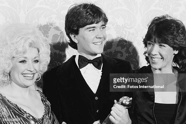 Actor Timothy Hutton holding his award for the film 'Ordinary People', with actress Lily Tomlin and singer Dolly Parton, at the Golden Globe Awards,...