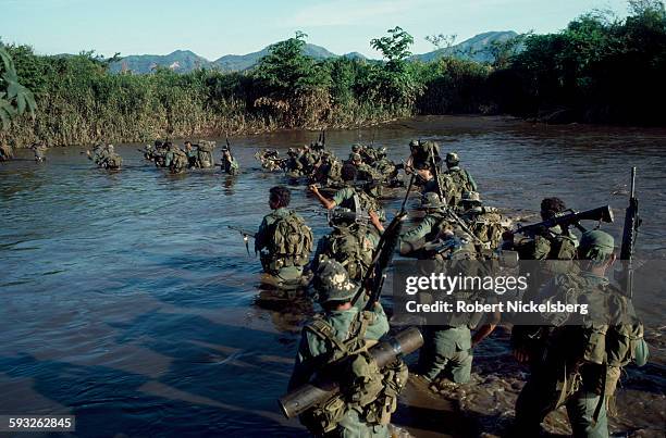 Members of the Salavadoran Army's Atlacatl Battalion cross a river during a military operation, San Miguel department, El Salvador, late August or...