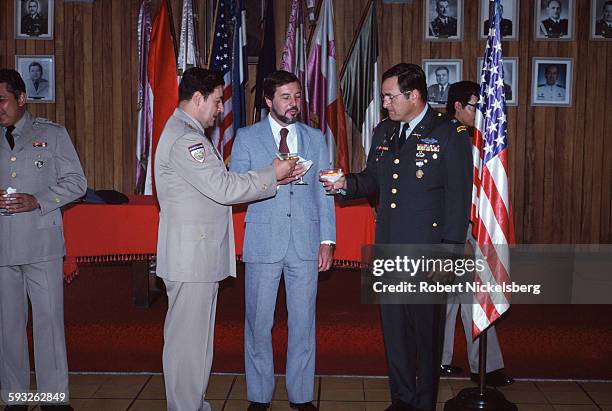 Salvadoran Minister of Defense General Carlos Eugenio Vides Casanova toasts US Army Colonel John D Waghelstein , as US Embassy deputy chief of...