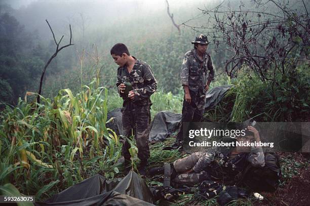 On a fog-enveloped hill, Salvadoran Army soldiers, from the Atlacatl Battalion, break camp in the early morning, San Miguel department, El Salvador,...