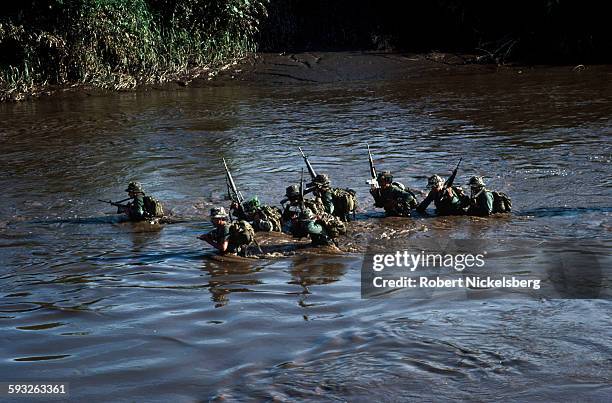 Members of the Atlacatl Battalion cross a river during a military operation, San Miguel department, El Salvador, late August or early September 1983.