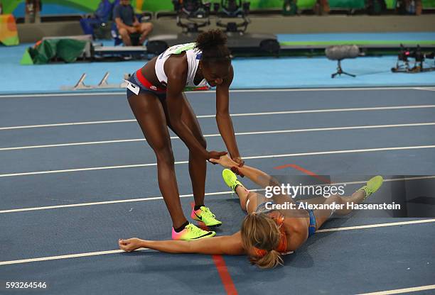 Dafne Schippers of the Netherlands gets help after having fallen while crossing the finish line to win the silver medal in the Women's 200 metres...