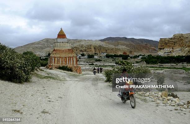 This picture taken on June 17, 2016 shows a Nepalese man riding his motor bike in Lo Manthang in Upper Mustang. A biannual trade fair in Tibet offers...