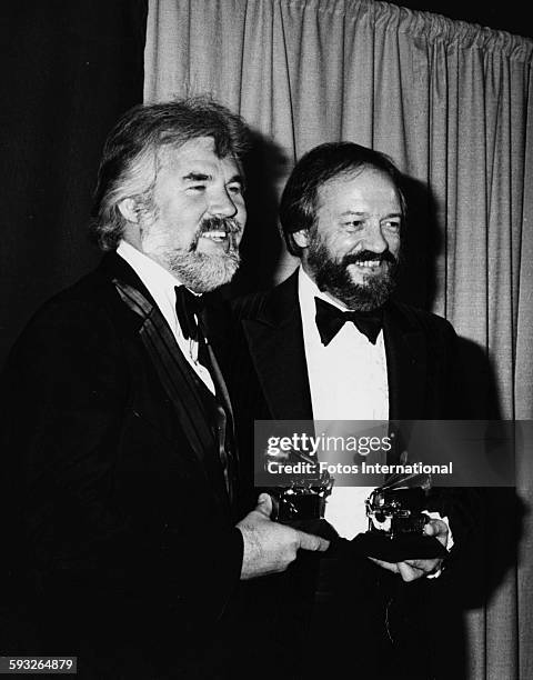 Musicians Kenny Rogers and Larry Butler holding their awards at the Grammy Awards, in the Shrine Auditorium in Los Angeles, February 1980.