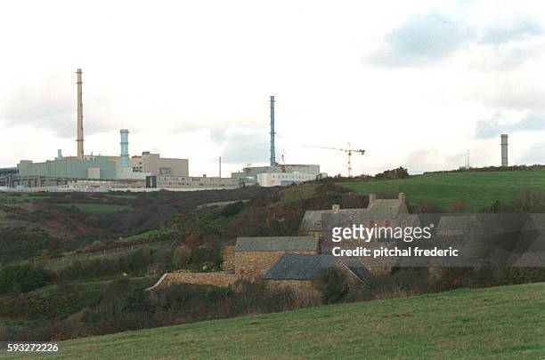 In the background, the COGEMA factory rises from the landscape. The factory at La Hague specializes in the treatment of used nuclear fuels discarded...