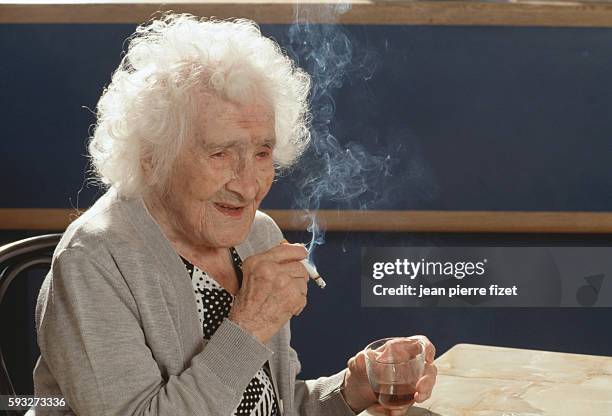 World's oldest person Jeanne Calment enjoys her daily cigarette and glass of red wine on the occasion of her 117th birthday.