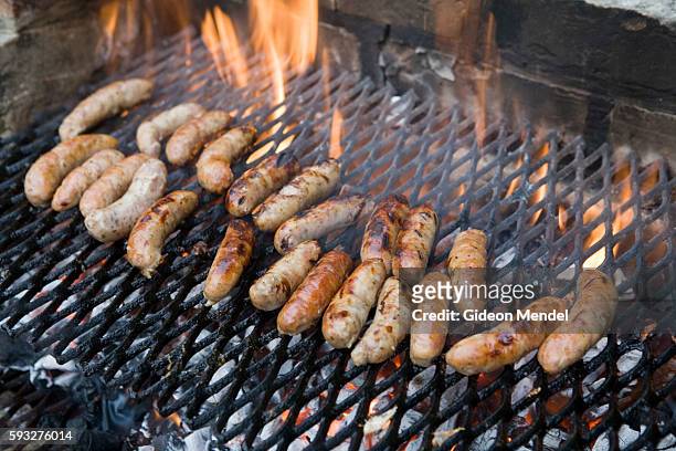 Sausages are cooked over hot coals and fire during a fund-raising church barbecue in the village of Great Chesterford in Cambridgeshire. | Location:...