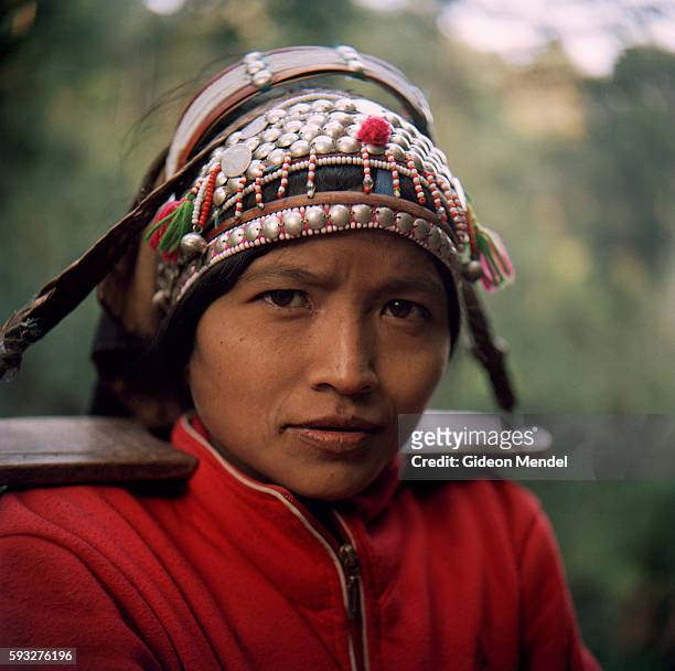 Portrait of an Akha woman wearing their intricately crafted traditional headress. She was walking on the trail to in the Ban Nam Lai Akha village....