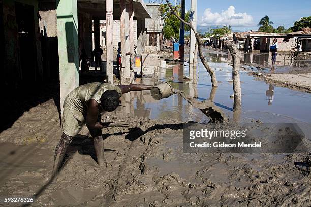 Miryam Jacques tries to bail muddy water out of family home in Gonaives. Two weeks earlier the entire city had been flooded during Hurricanes Ike and...