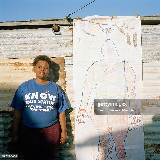 Akona Jazi, poses with her body map outside her tin shack in the Khayelitsha squatter community. She was diagnosed as HIV positive in 2000 when she...