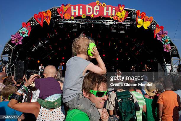 Young boy wears hearing defenders, also known as hearing protection earphones as he enjoys a performance by the energetic fold band Bellowhead at...