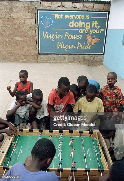 Children play table football in the courtyard of Africa Directions, a youth-led recreational programme geared towards the needs of young people in...