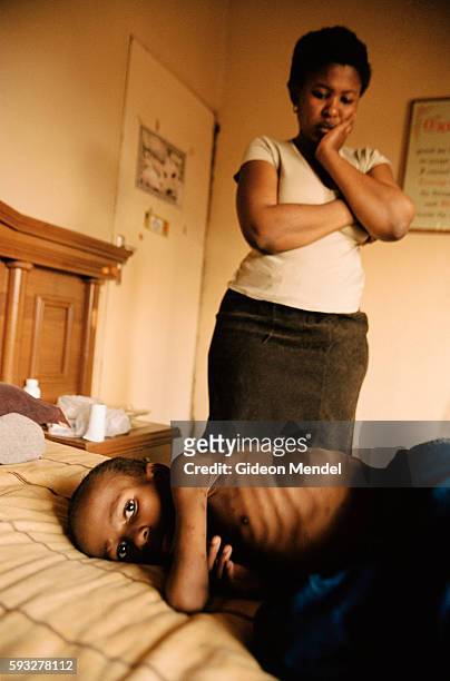 An HIV positive woman with her 10-year-old child who has AIDS and is extremely ill. Neither of them were able to access the anti-retroviral therapy...