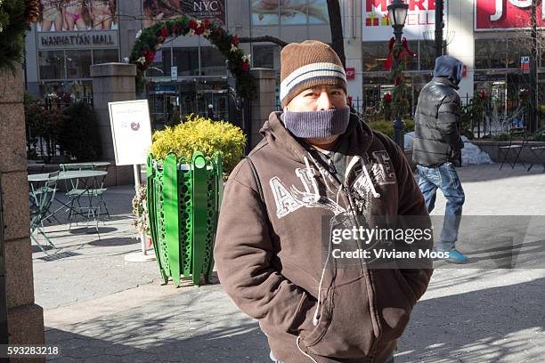 Men and Women covered and bundled trying to protect themselves from the icy polar vortex cold temperatures and wind that descended in New York and...