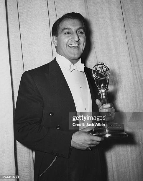 Actor Danny Thomas holding her Best Actor award at the Emmy Awards, 1955.