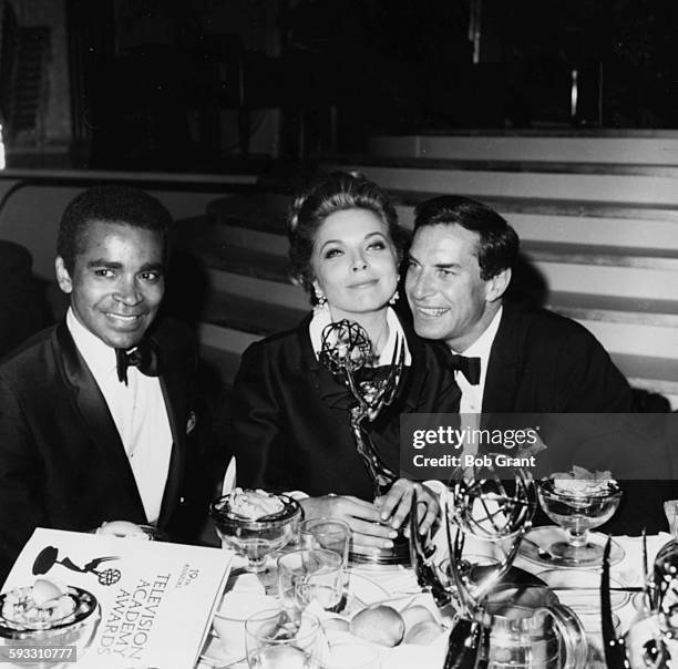 Actors Greg Morris and Martin Landau sitting with actress Barbara Bain as she holds on to her award for the show 'Mission: Impossible', at the Emmy...