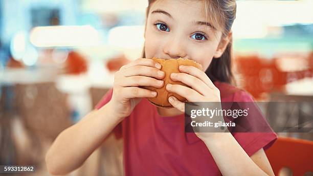 little girl enjoying a burger. - kid eating burger bildbanksfoton och bilder