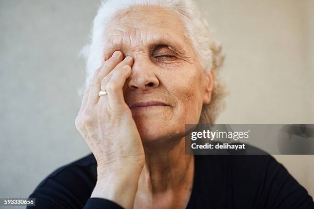 senior woman - rubbing eyes stock pictures, royalty-free photos & images