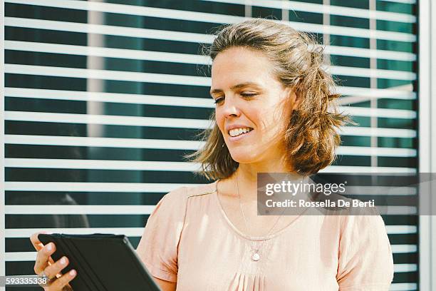 portrait of successful businesswoman using tablet in urban landscape - zuidas stockfoto's en -beelden